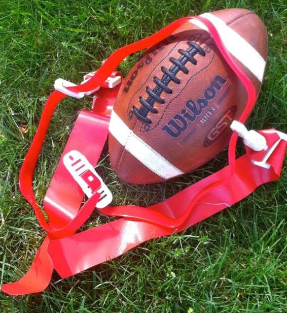 Football with red flag belt on the grass