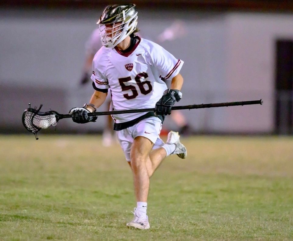 High school lacrosse player running with the ball